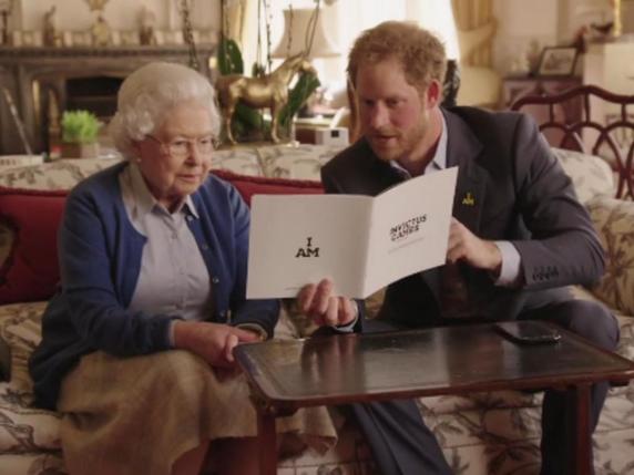 La photo issue d'une vidéo transmise par Kensington Palace  montre la reine d'Angleterre avec son petit-fils Harry tenant une brochure d'Invictus Games. © KEYSTONE/AP @KENSINGTONROYAL