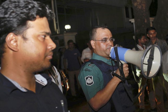 La police du Bangladesh en appelle au calme à proximité du restaurant attaqué. © KEYSTONE/AP