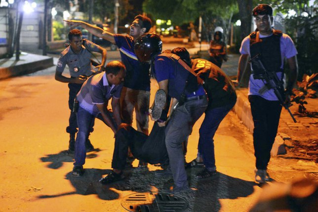 Les forces de sécurité aident à évacuer un blessé après l'attaque de Dacca. © KEYSTONE/AP