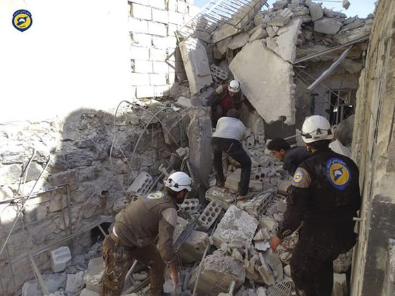 Des casques blancs, les sauveteurs de la défense civile dans les zones rebelles, cherchent des survivants dans les décombres des maisons de Hass. © KEYSTONE/AP Syrian Civil Defense White Helmets/UNCREDITED