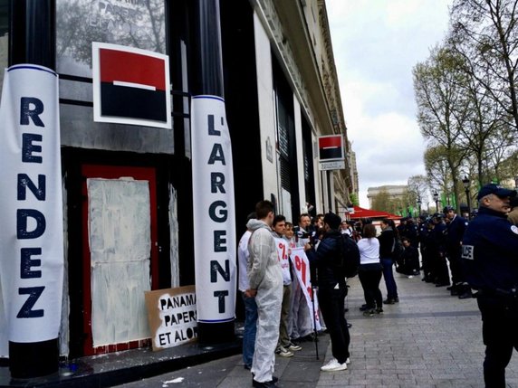 Une cinquantaine de militants d'Attac ont repeint l'entrée d'une succursale de la Société générale sur les Champs-Elysées à Paris. © Attac France