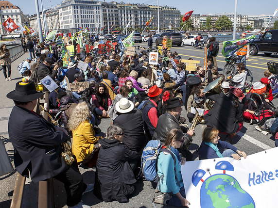 Les manifestants de la marche pour le climat à Genève se sont assis comme les participants aux centaines d'autres rassemblements. © KEYSTONE/SALVATORE DI NOLFI