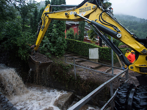 Un cours d'eau est débarrassé de matériel près de Brusino Arsizio (TI), mercredi matin, après des inondations sur la route cantonale voisine. © KEYSTONE/TI-PRESS/FRANCESCA AGOSTA