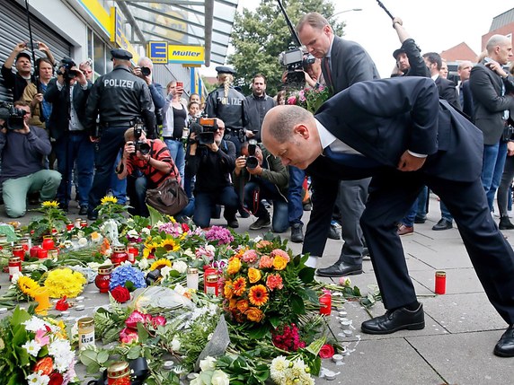 Le maire de Hambourg Olaf Scholz et le ministre de l'intérieur de la ville Andy Grote déposent des fleurs sur le lieu de l'attaque. © KEYSTONE/EPA/MARIUS ROEER