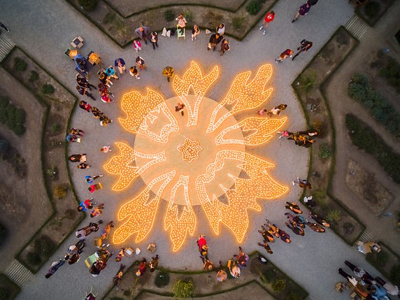 L'artiste Muma aidé de 660 volontaires a allumé quelque 50'000 bougies dans les jardins du château de Prangins. © KEYSTONE/VALENTIN FLAURAUD