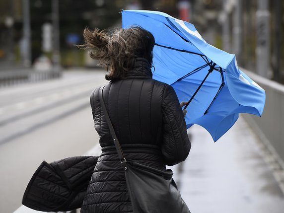 Les passants ont dû s'accrocher à leur parapluie lors du passage de Ciara en Suisse. © KEYSTONE/ANTHONY ANEX