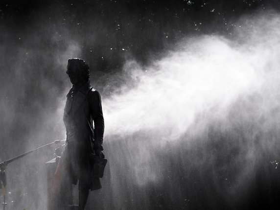 Un ouvrier a recours à un jet d'eau à haute pression pour nettoyer la statue de David de Pury à Neuchâtel. Des inconnus l'ont maculée de peinture rouge dans la nuit de dimanche à lundi. © KEYSTONE/LAURENT GILLIERON