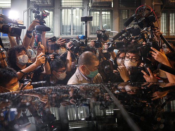 Jimmy Lai quittant une station de police entouré par les médias après sa libération © KEYSTONE/EPA/JEROME FAVRE