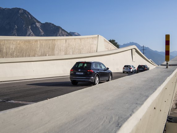 Des véhicules circulent sur le pont sur le Rhône à Riddes pendant que ce dernier est soulevé millimètre par millimètre par de puissants vérins. © KEYSTONE/JEAN-CHRISTOPHE BOTT