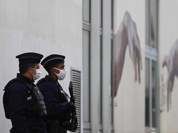 Deux policiers français montent la garde à l'ancien siège de Charlie Hebdo, là où a lieu l'attaque au hachoir. © KEYSTONE/EPA/IAN LANGSDON