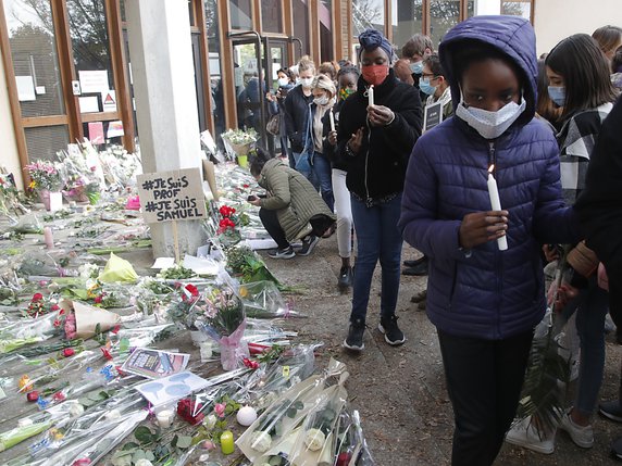 Des dizaines d'élèves et de parents ont déposé une rose blanche au pied des grilles du collège du Bois d'Aulne à Conflans-Sainte-Honorine. © KEYSTONE/AP/Michel Euler