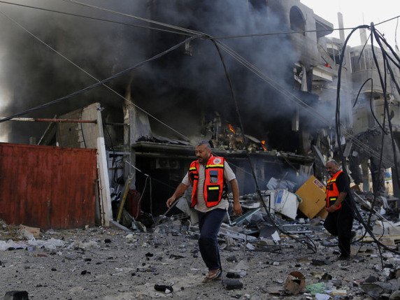 Des pompiers palestiniens inspectent les restes d'une usine de lait