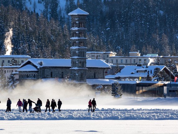 Des promeneurs profitent du beau et de la neige à St-Moritz (arc)