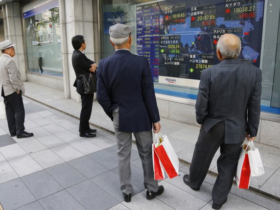 Des passants consultent la Bourse de Tokyo (archives)