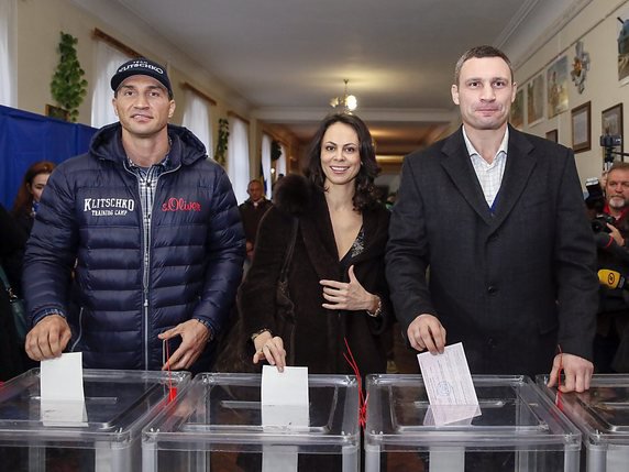 Vitali Klitschko (droite) est allé voter avec son épouse Natalia et son frère Vladimir Klitschko. © KEYSTONE/EPA/ROMAN PILIPEY