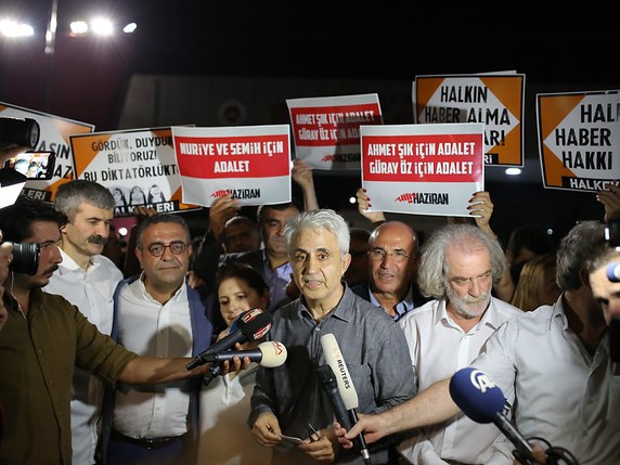Le caricaturiste de Cumhuriyet Musa Kart (au centre) au moment de sa libération © KEYSTONE/EPA