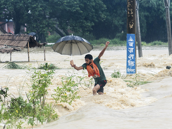 Un Népalais tentant de traverser une rue inondée à Birgunj, au Népal © KEYSTONE/AP/MANISH PAUDEL