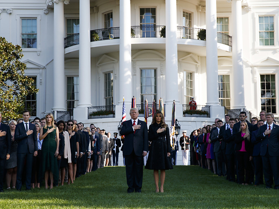 Entourés de nombreux collaborateurs, Donald et Melania Trump se sont recueillis en silence dans les jardins de la Maison Blanche. © KEYSTONE/AP/EVAN VUCCI