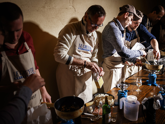 Des concurrents préparent leur fondue lors du deuxième Mondial de la fondue samedi à Tartegnin (VD). © KEYSTONE/VALENTIN FLAURAUD