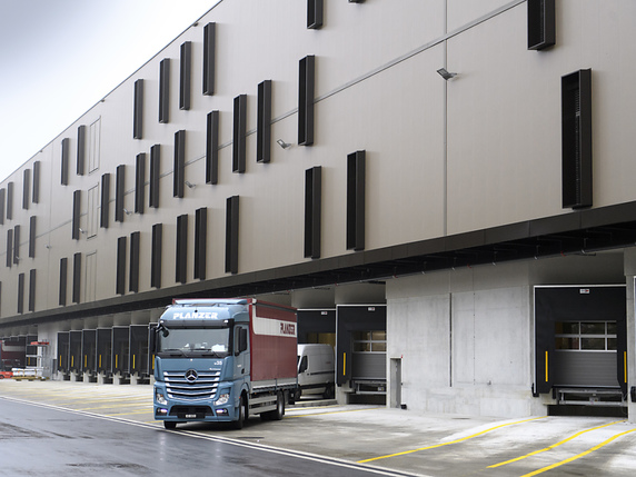 Le nouveau bâtiment du centre Planzer Transports à Penthalaz (VD) a été présenté jeudi aux médias. Il est présenté comme la plus grande infrastructure de transfert de marchandises "rail-route" de Suisse romande. © KEYSTONE/LAURENT GILLIERON