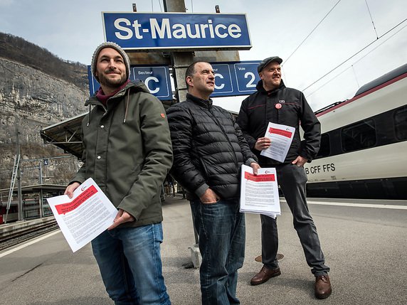 Le conseiller national Mathias Reynard, président de l’Union syndicale valaisanne, Blaise Carron, vice-président de l’USVs, et René Zürcher, secrétaire général du syndicat du personnel des transports SEV (de gauche à droite) ont dénoncé mardi la suppression du guichet de la gare de St-Maurice (VS). © KEYSTONE/OLIVIER MAIRE