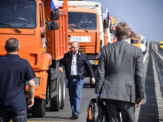Suivi d'une dizaine de camions également orange et autres véhicules, le président russe Vladimir Poutine a roulé sur le "Pont de Crimée". © KEYSTONE/AP POOL AFP/ALEXANDER NEMENOV