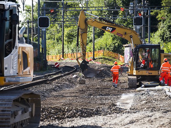 Des ouvriers travaillent sur le chantier de la gare de La Conversion (VD). © KEYSTONE/JEAN-CHRISTOPHE BOTT