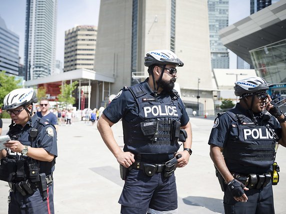 De nombreux policiers étaient visibles jeudi dans les rues de Toronto. © KEYSTONE/AP The Canadian Press/CHRISTOPHER KATSAROV