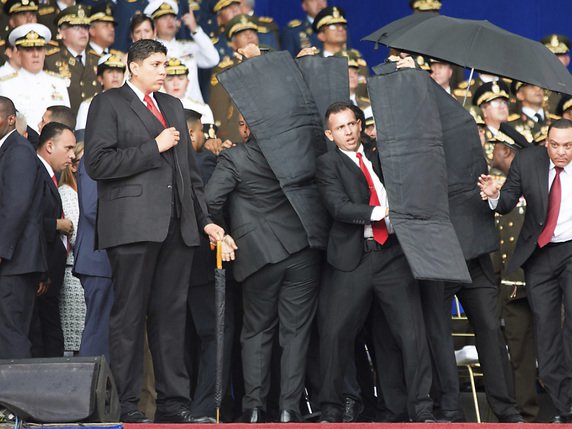 Des gardes du corps ont protégé le président du Venezuela Nicolas Maduro avec des panneaux pare-balles afin de l'évacuer de l'estrade sur laquelle il s'adressait à des milliers de soldats lors d'une parade militaire. © KEYSTONE/AP Xinhua