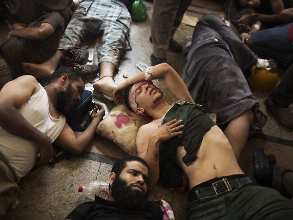 Sur cette photo datant du 14 août 2013, des partisans du président égyptien déchu Mohammed Morsi sont allongés, blessés, sur le sol d'un hôpital de fortune lors d'un sit-in au Caire (archives). © KEYSTONE/AP/MANU BRABO