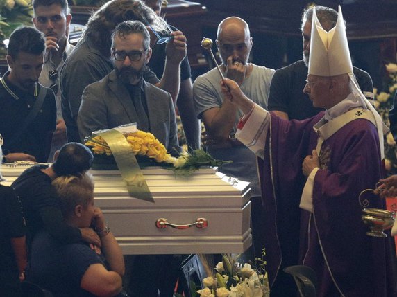 L'archevêque de Gênes, Angelo Bagnasco, bénit le cercueil d'un enfant de neuf ans mort dans la catastrophe. © KEYSTONE/AP/GREGORIO BORGIA