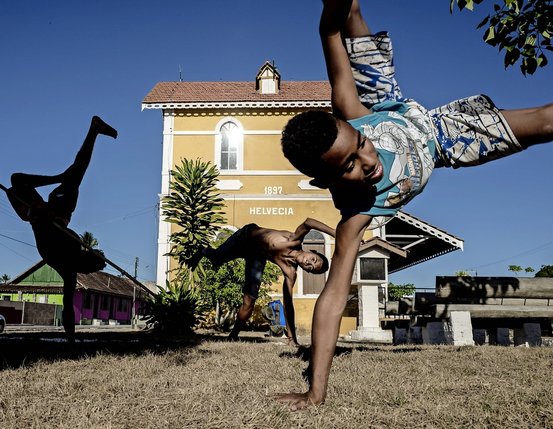 Des élèves de l’école Arte Capoeira Bahia exécutent des figures devant la gare d’Helvécia, d’où était exporté le café.  © Dom Smaz