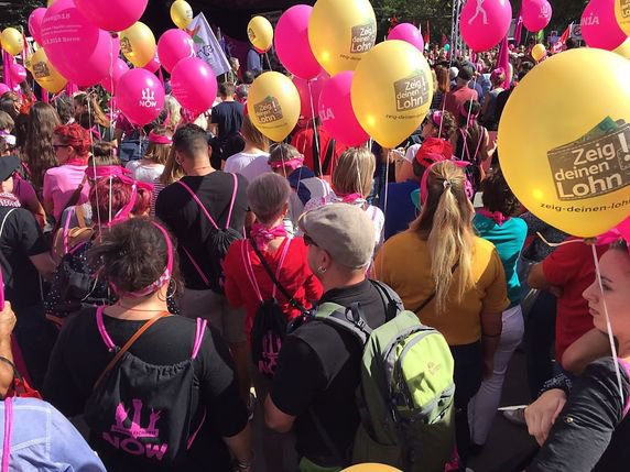 Les manifestants ont défilé avec des ballons colorés pour exiger l'égalité de salaire entre hommes et femmes. © Christian Zingg / Keystone-ATS