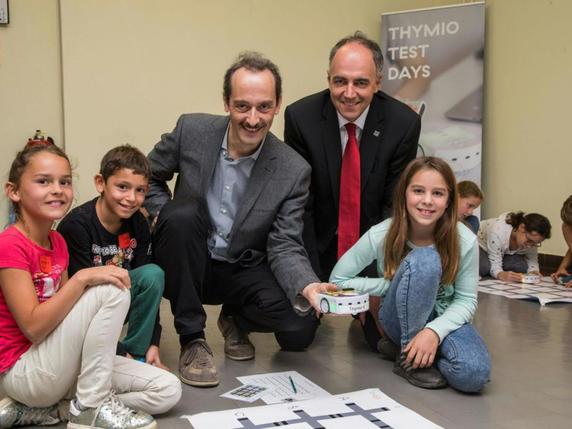 Jeudi, des élèves valaisans ont découvert le robot Thymio, que son concepteur Francesco Mondada tient dans sa main. © Keystone/ETIENNE_BORNET