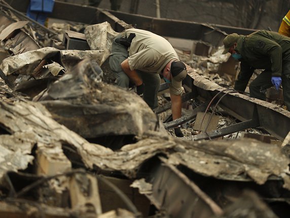 Les policiers poursuivent la recherche de corps dans les décombres des maisons à Paradise. © KEYSTONE/AP/JOHN LOCHER