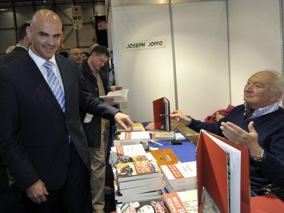 Le conseiller fédéral Alain Berset (à gauche) en discussion avec l'écrivain francais Joseph Joffo (à droite) lors de l'ouverture du Salon International du Livre et de la Presse en avril 2012 à Genève (archives). © Keystone/MARTIAL TREZZINI