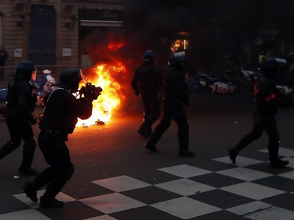 La police anti émeute devant des véhicules incendiés à Paris © KEYSTONE/EPA/IAN LANGSDON