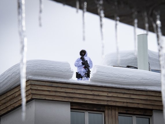 Tenues de camouflage blanches de rigueur pour les forces spéciales, qui étaient déjà en place sur les toits de Davos lundi. © KEYSTONE/GIAN EHRENZELLER