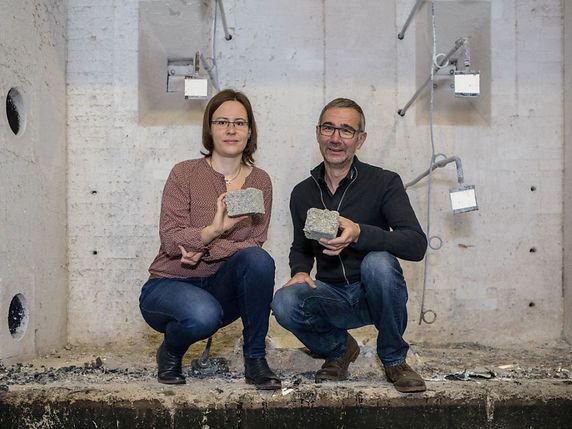Ce ne sont pas des pavés que tiennent Franziska Grüneberger et Willi Senn, mais des morceaux cubiques du coupe-feu en papier recyclé qu'ils ont développé. © Empa/Keystone