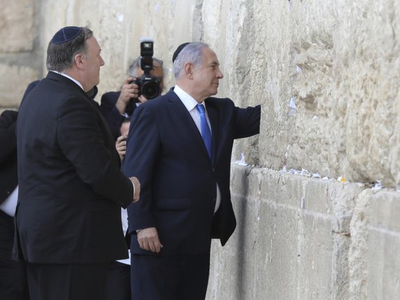 Mike Pompeo (à gauche) et  Benjamin Netanyahu (à droite) ont chacun à leur tour glissé leur prière inscrite sur un petit papier entre les pierres de l'imposant Mur des Lamentations à Jérusalem-Est. © Keystone/AP POOL EPA/ABIR SULTAN