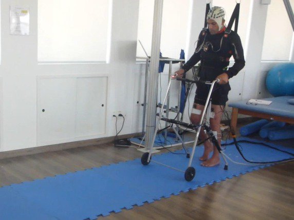Les patients partiellement soutenus par un harnais utilisent leur propre activité cérébrale pour contrôler l’envoi de pulsions électriques à un total de seize muscles dans leurs jambes. © AASDAP/EPFL