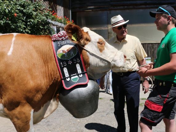 Le conseiller fédéral Guy Parmelin (à gauche) a pu faire la connaissance d'une vache figurante de la Fête des Vignerons. © USP