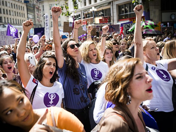 Poing levé, des femmes manifestent sur la place Saint-François à Lausanne. © KEYSTONE/JEAN-CHRISTOPHE BOTT