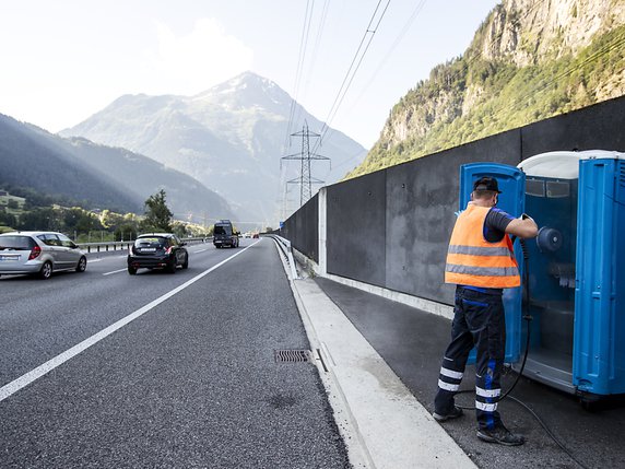 Alexandar Djordjevic nettoie les toilettes mobiles directement sur l'A2, ici au portail nord du Gothard, près de Wassen (UR). © KEYSTONE/ALEXANDRA WEY