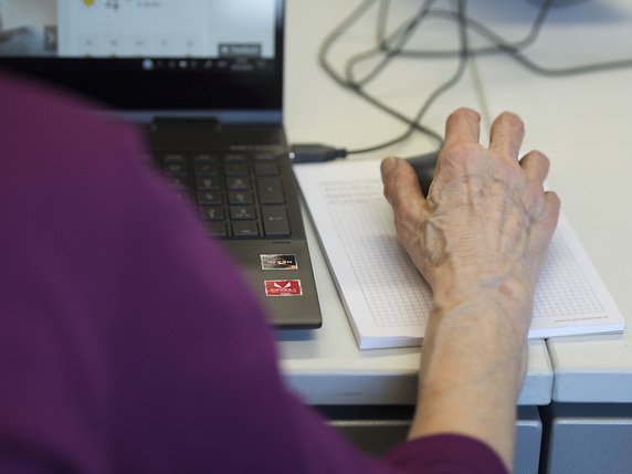 Une aide informatique ou administrative peut faire partie des coups de main demandés par la personne âgée (photo symbolique). © KEYSTONE/CHRISTIAN BEUTLER