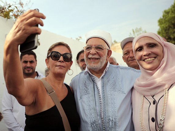 Pause selfie à la sortie d'un bureau de vote pour le candidat du parti islamiste Ennahdha, Abdelfattah Mourou. © KEYSTONE/AP/MOSA'AB ELSHAMY