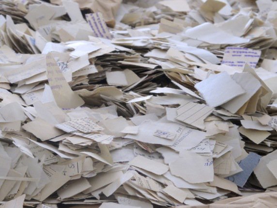 Depuis le début en 1995 de la reconstitution manuelle des documents, quelque 500 sacs de fragments, soit l'équivalent de plus de 1,5 million de pages, ont été réassemblés... mais il en reste environ 55 millions à reconstituer (archives). © KEYSTONE/AP/FRANK JORDANS