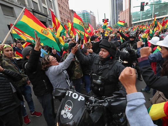 Des milliers d'habitants ont déferlé dans les rues bolivienne pour célébrer l'annonce de la démission de leur président Evo Morales, agitant le drapeau bolivien entre rires et larmes. © KEYSTONE/EPA EFE/MARTIN ALIPAZ