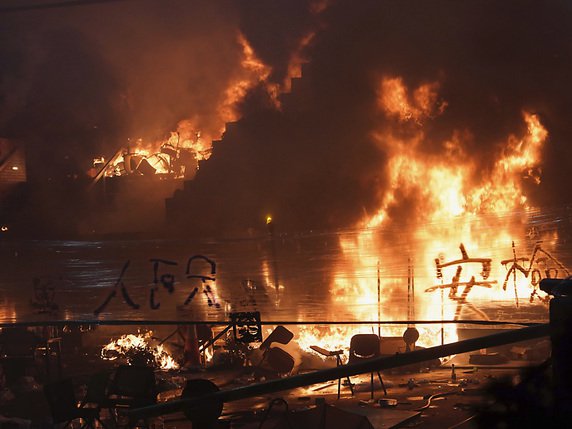 L'incendie fait rage à l'entrée du campus où les étaient retranchés. © KEYSTONE/AP/VINCENT YU