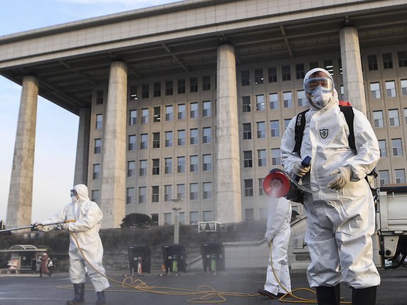 Le ministre de la Défense sud-coréen a qualifié la situation de son pays concernant le coronavirus de "grave". Ici, des travailleurs désinfectent la place devant l'Assemblée nationale à Séoul. © KEYSTONE/EPA/YONHAP